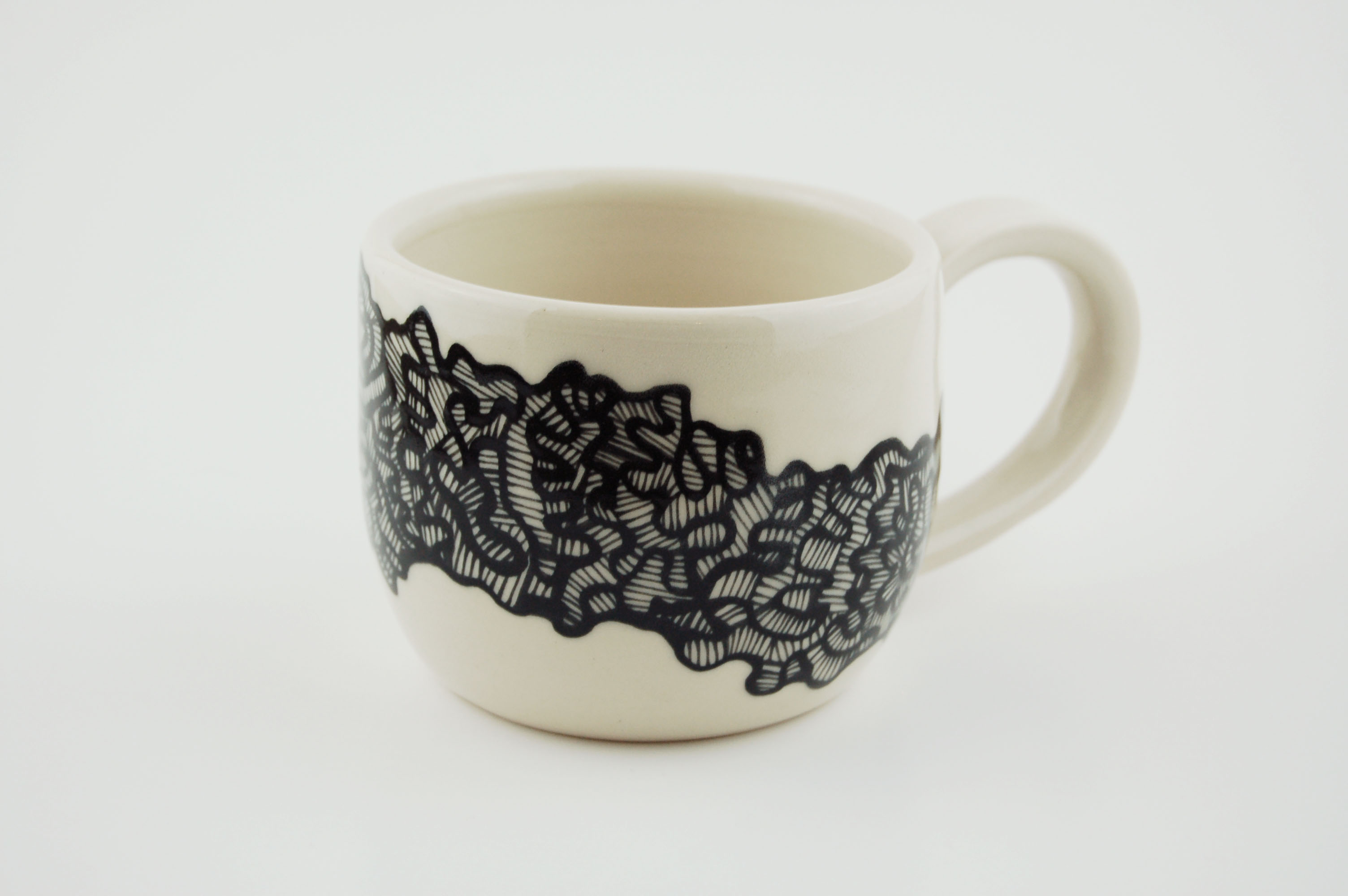 Ceramic mug with black lines on off-white clay